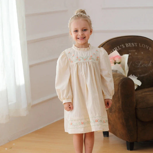 Apricot girls dress with hand-embroidered floral patterns and puff sleeves with elasticated cuffs