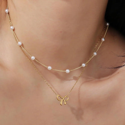 Double layer pearl choker with bow pendant in gold and silver options