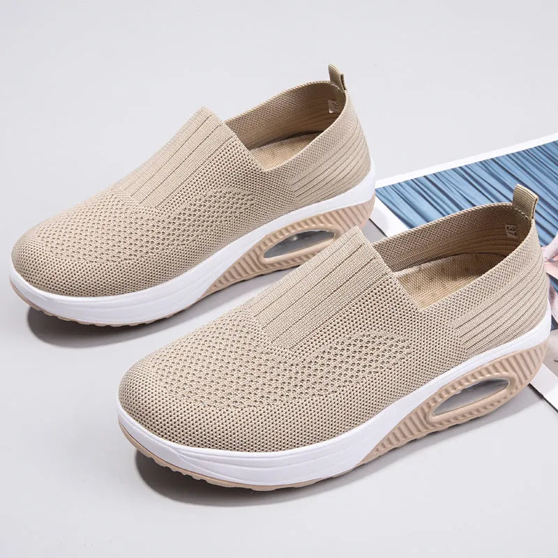 Women's beige mesh running shoes with round toe and air cushion midsole on a grey background.