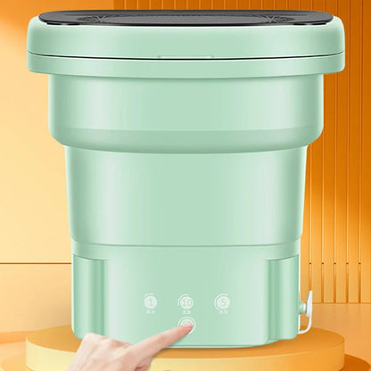 Green portable folding washing machine showing collapsed storage size and antibacterial blue light feature