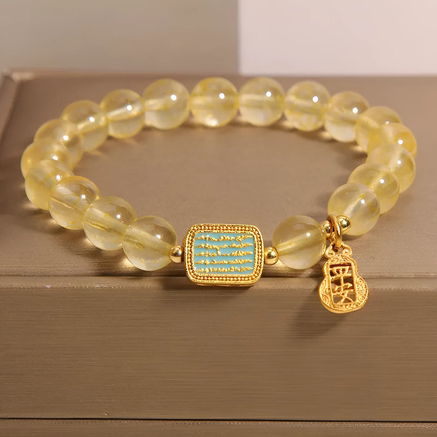 Women's bracelet made from yellow citrine crystal with rhinestone decoration on a white background.