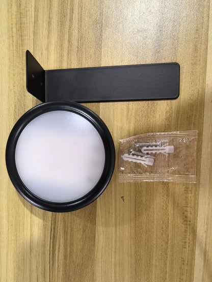 Black magnetic LED painting lamp with remote control on a white wall.