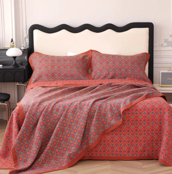 Three-piece cotton gauze bed set with floral print, showing blanket and pillowcases on a bed.