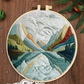 Embroidery DIY landscape kit with bamboo frame, printed fabric, thread, and needles for textile art