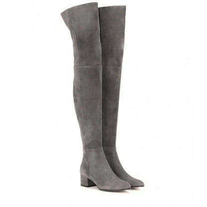 Women's grey suede over-the-knee flat boots with pointed toe and thick rubber sole on a neutral background