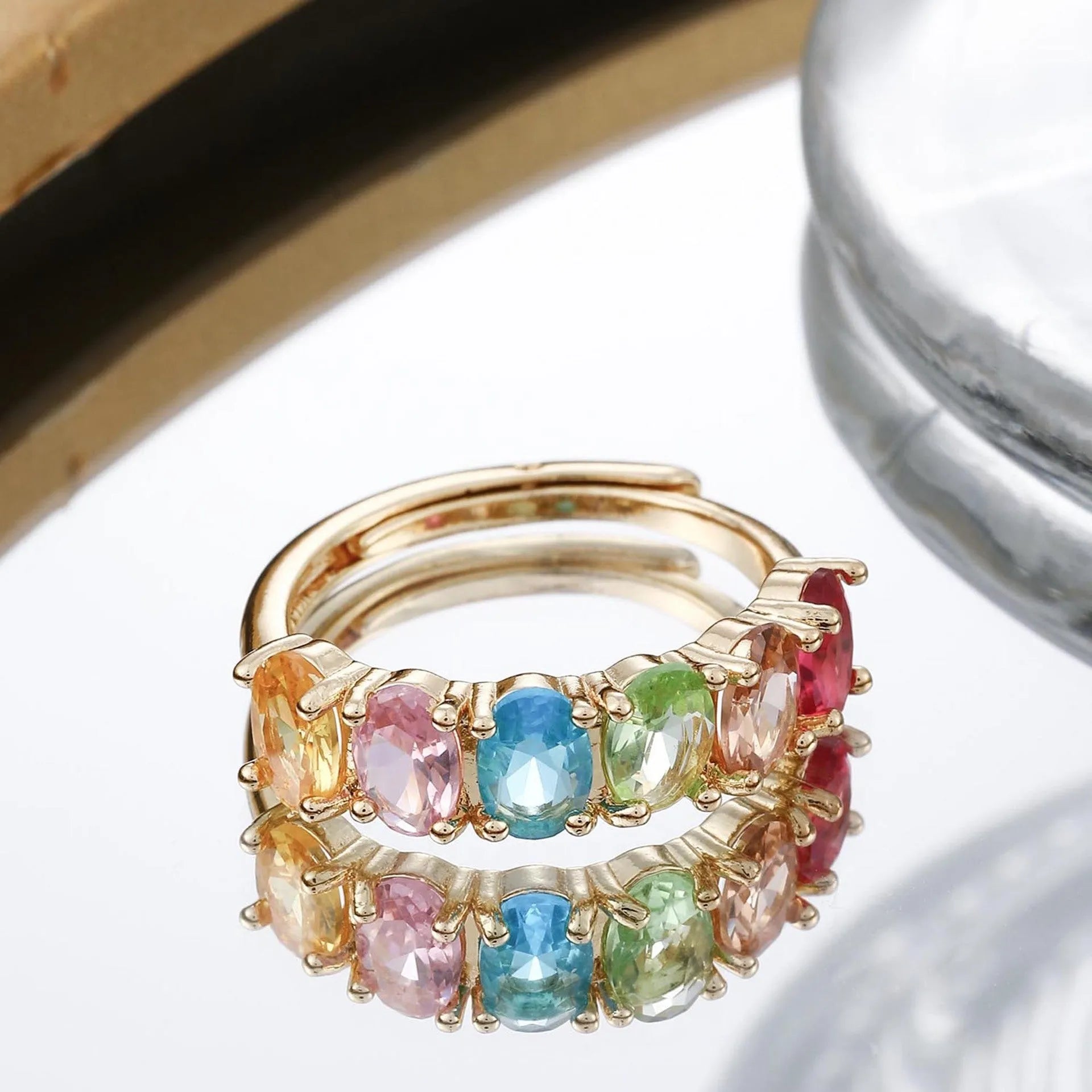 Gold electroplated adjustable open band zircon ring on white background