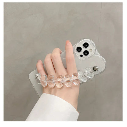 Transparent TPU iPhone case with love bracelet and heart chain design on a table.