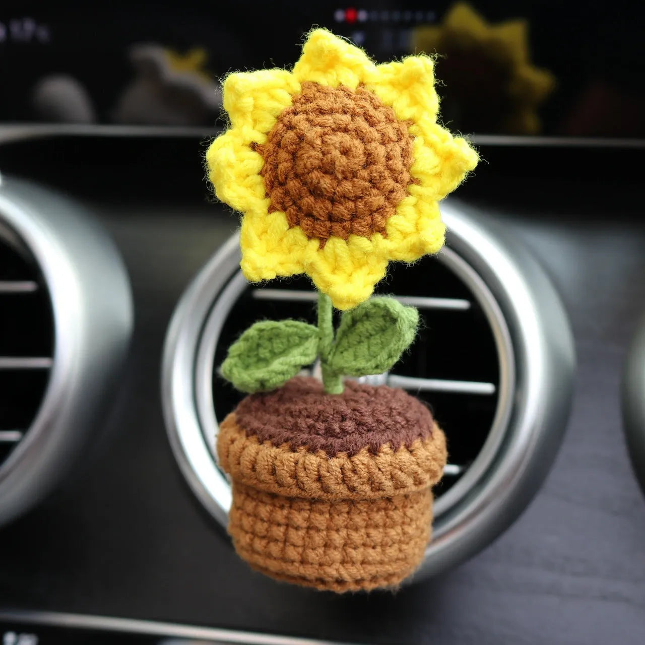 Creative wool potted plant car air vent clip aromatherapy pendant on a car vent.