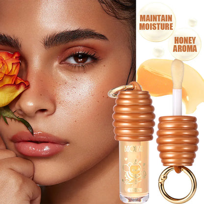 Moisturising honey lip gloss on a silver keychain against a plain background.