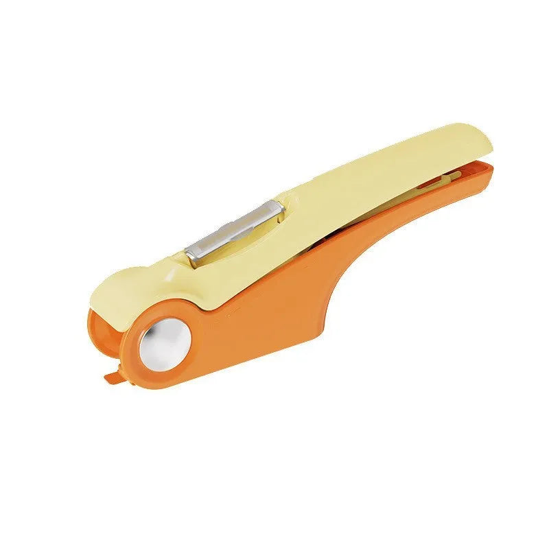 White manual garlic press with stainless steel mechanism on wooden kitchen surface