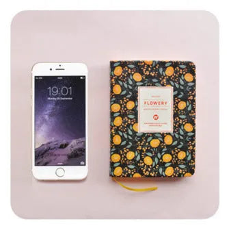 Bo Shide floral notepad with fabric-imitation leather cover in green, shown open on a desk.