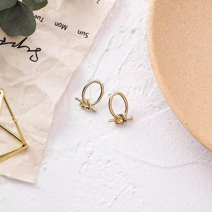 Gold alloy stud earrings with oval knotted design