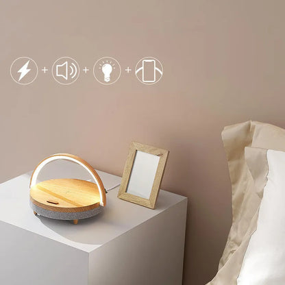 Wireless charging LED night light with Bluetooth speaker in marble pattern finish on a wooden desk.