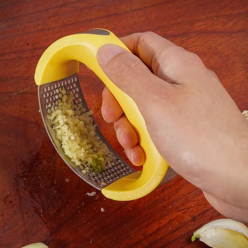 Stainless steel garlic press with ergonomic handle in kitchen setting
