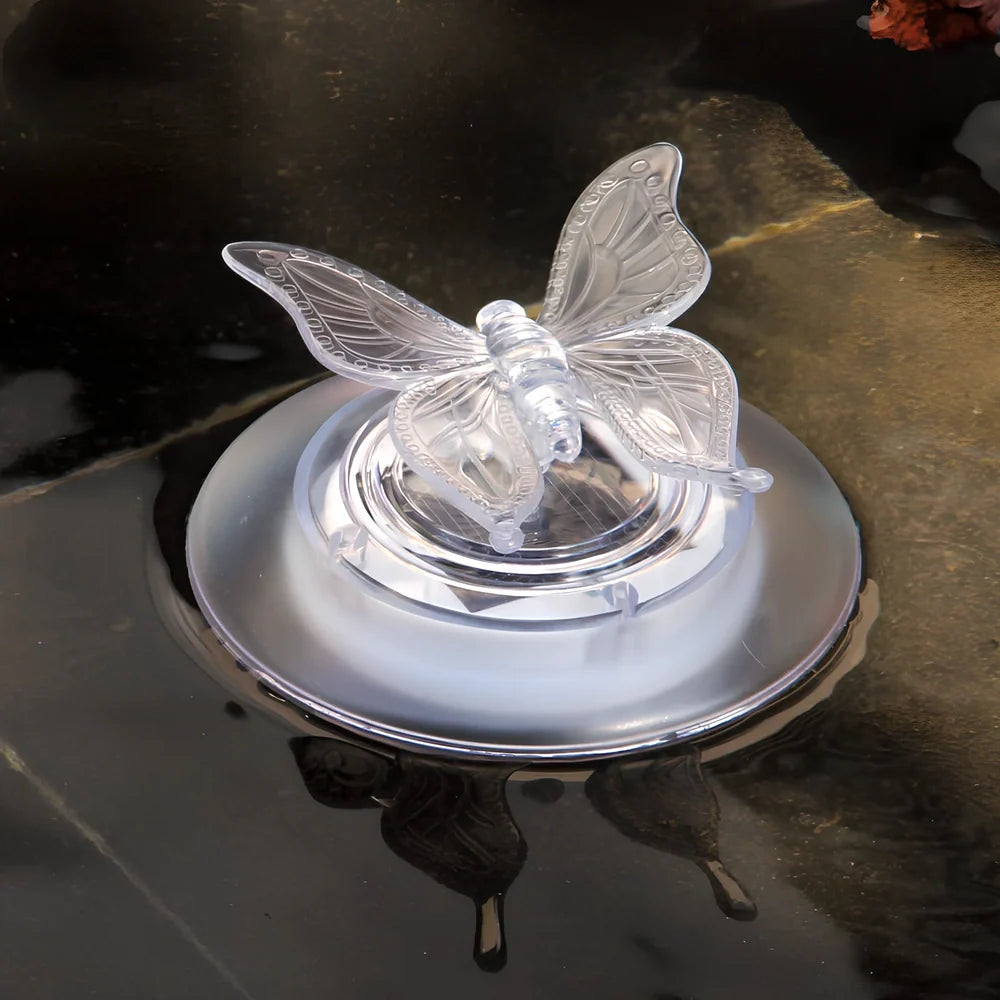 Solar LED float lamp with butterfly design floating on garden pond water surface