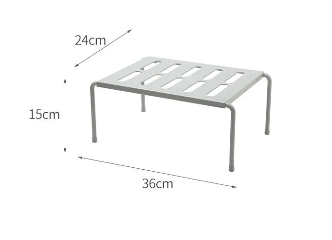 White telescopic kitchen storage rack at adjustable height on a countertop