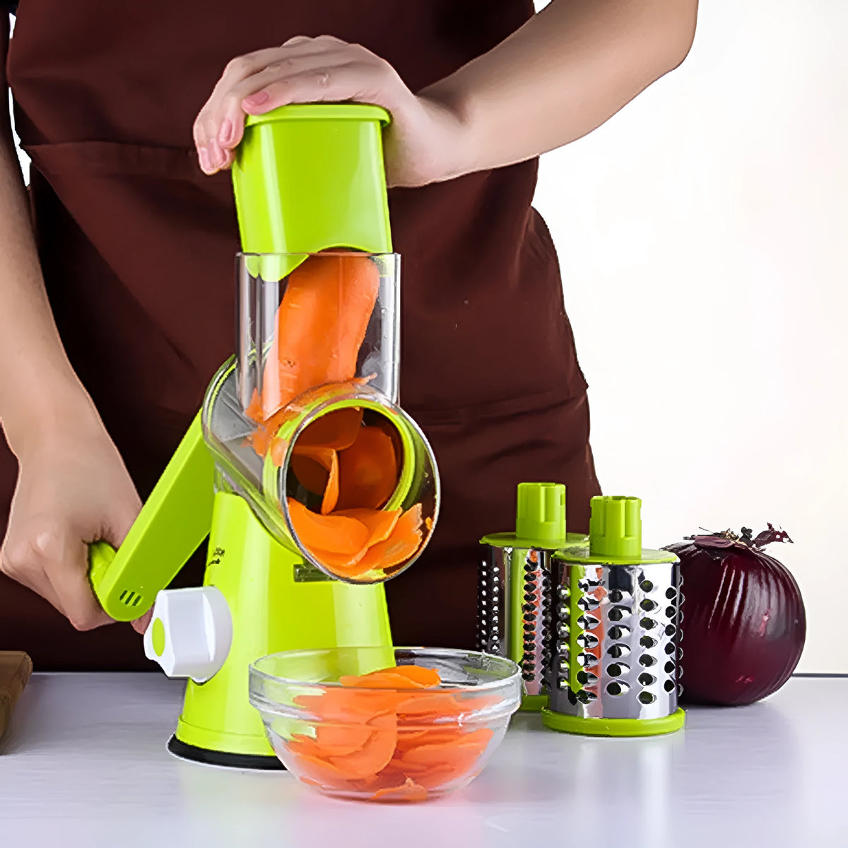 Round mandoline vegetable slicer with three stainless steel blades and a rubber suction base, in blue green colour.