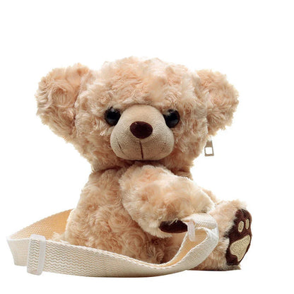 A plush teddy bear crossbody messenger bag with an adjustable shoulder strap and a zippered interior pocket for convenient storage.