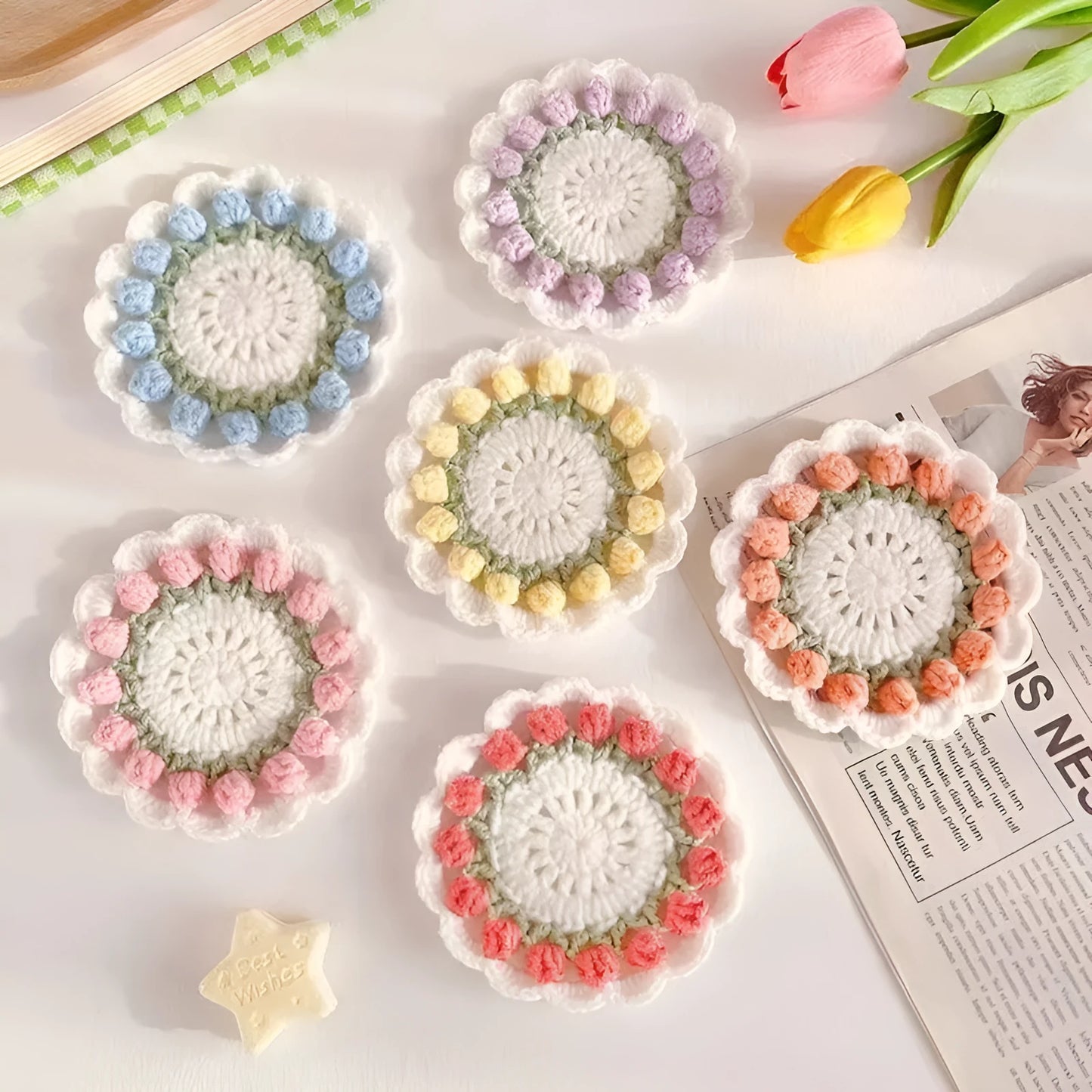 Handmade woven flower coaster in cotton and linen on a wooden table.