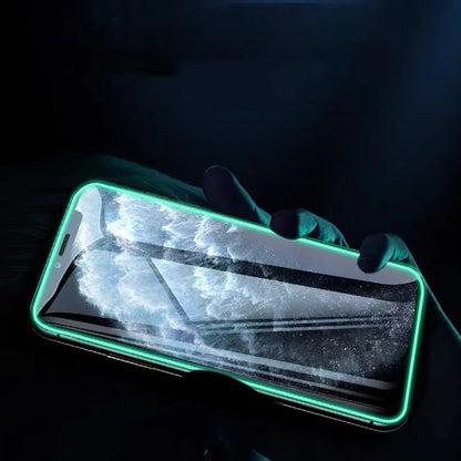 Luminous tempered glass screen protector glowing in dark next to iPhone