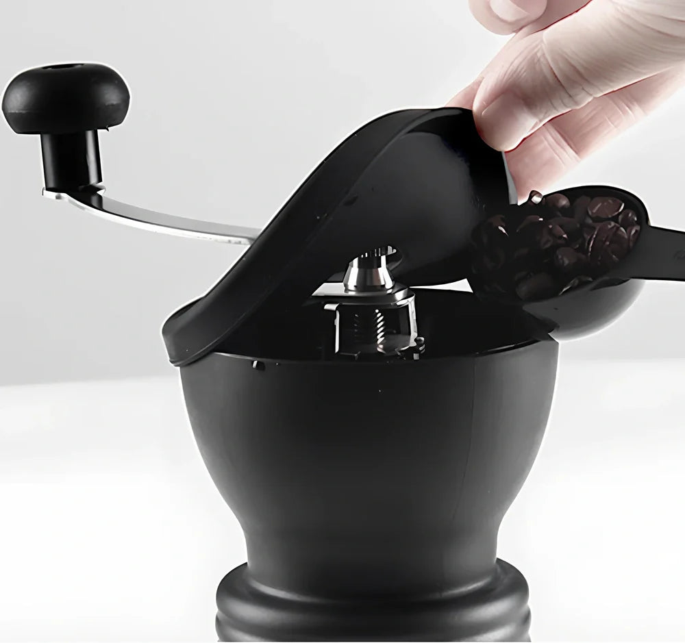 Manual coffee grinder with beech wood body and stainless steel grinding mechanism on kitchen counter