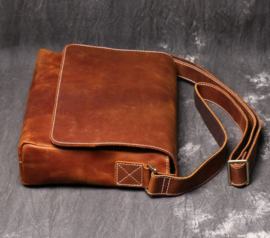 Vintage brown leather mens messenger bag with flap open, showing internal phone pouch and zipper pocket.