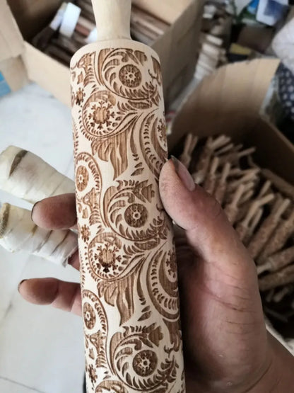 Wooden rolling pin with engraved Christmas patterns including reindeer and snowflakes on a 45cm long barrel.