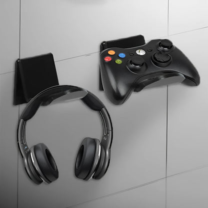 A universal black game controller mounting bracket shown installed on a wall.