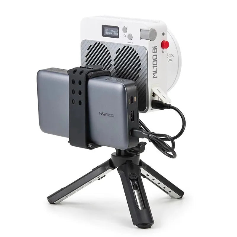 Shenniu ML100Bi 200W LED photography fill light with lenses, battery handle, and accessories on a studio table.