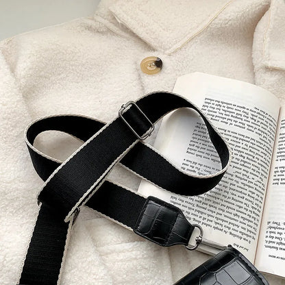 Vintage crossbody bag in black showing 20cm width, crossbody strap, and front storage compartment