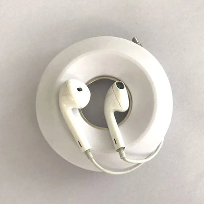 Silicone donut cord reel with magnet for organising mobile phone and headphone cables in light grey colour