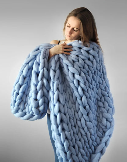 Hand woven wool blanket with soft chenille texture in navy blue colour draped over sofa