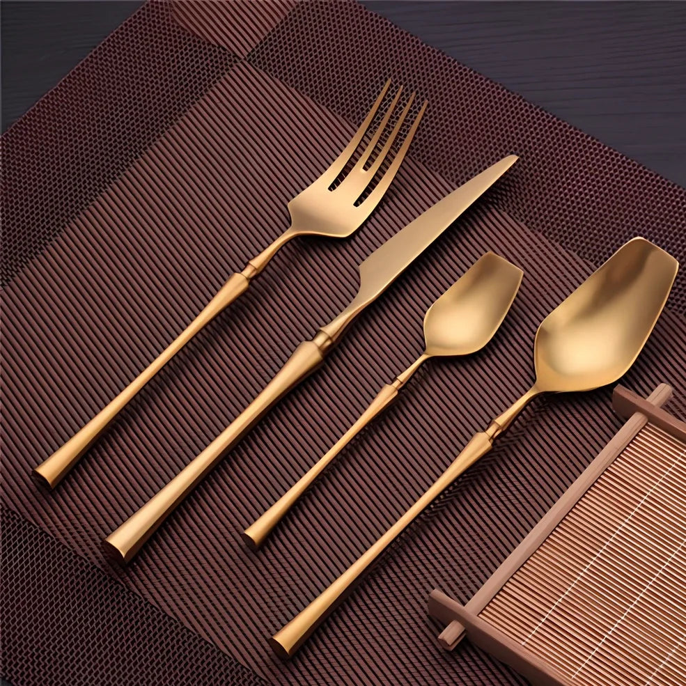 Four-piece stainless steel cutlery set showing main knife, fork, spoon, and teaspoon with mirror finish