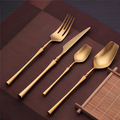 Four-piece stainless steel cutlery set showing main knife, fork, spoon, and teaspoon with mirror finish