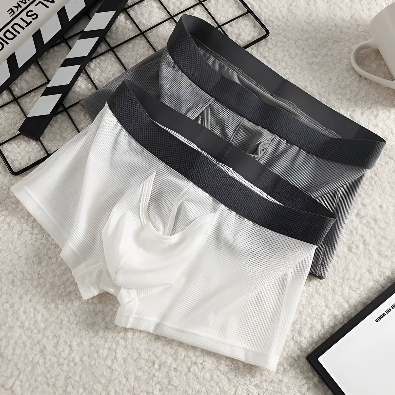 Men's ice silk boxer briefs in black, white, and grey colours showing mesh fabric and low-waist design