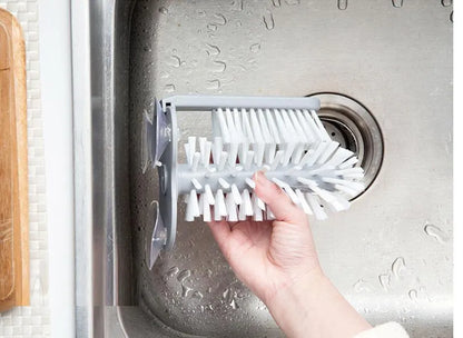 Grey rotating double-head cup brush with suction cups for wall mounting.