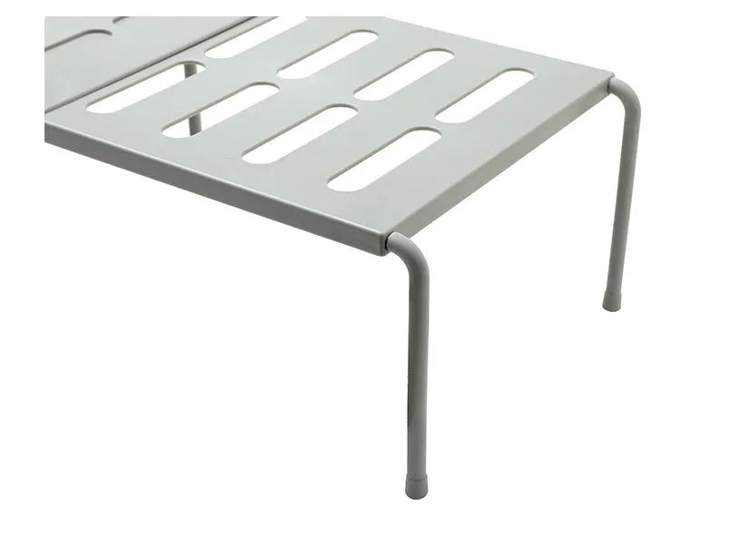 White telescopic kitchen storage rack at adjustable height on a countertop