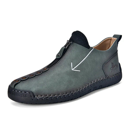 Men's black leather boots with front zipper, hand-stitched detailing, and rubber sole on a neutral background