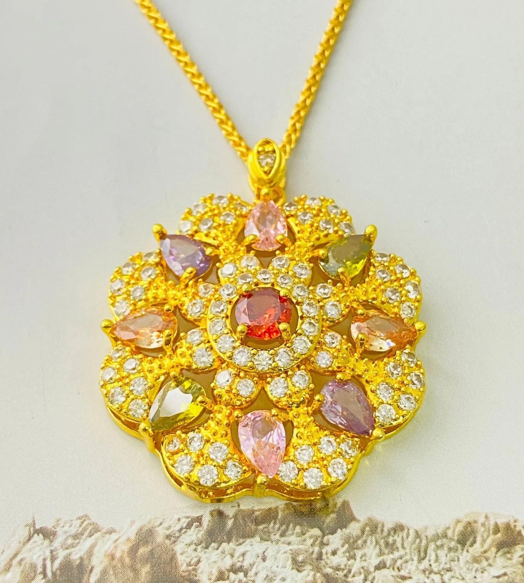 Close-up of a women's gold-coloured flower pendant necklace with a bright zircon stone centre.