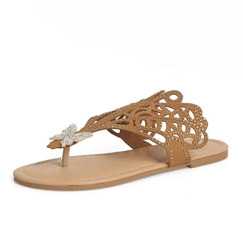 Women's black slip-on flip-toe sandals with rhinestone accents and hollow flat-heeled design on a light background