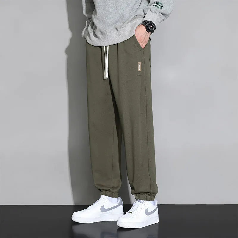 Men's loose gray casual sports trousers with drawstring waist on a hanger