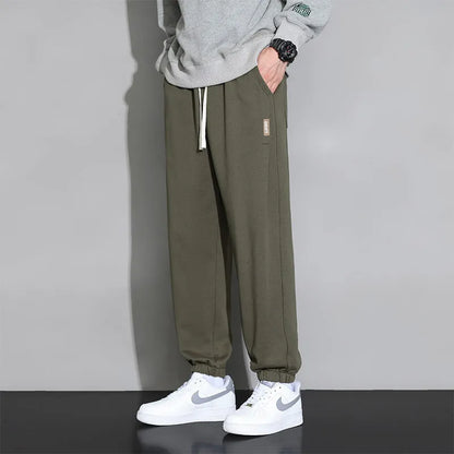 Men's loose gray casual sports trousers with drawstring waist on a hanger