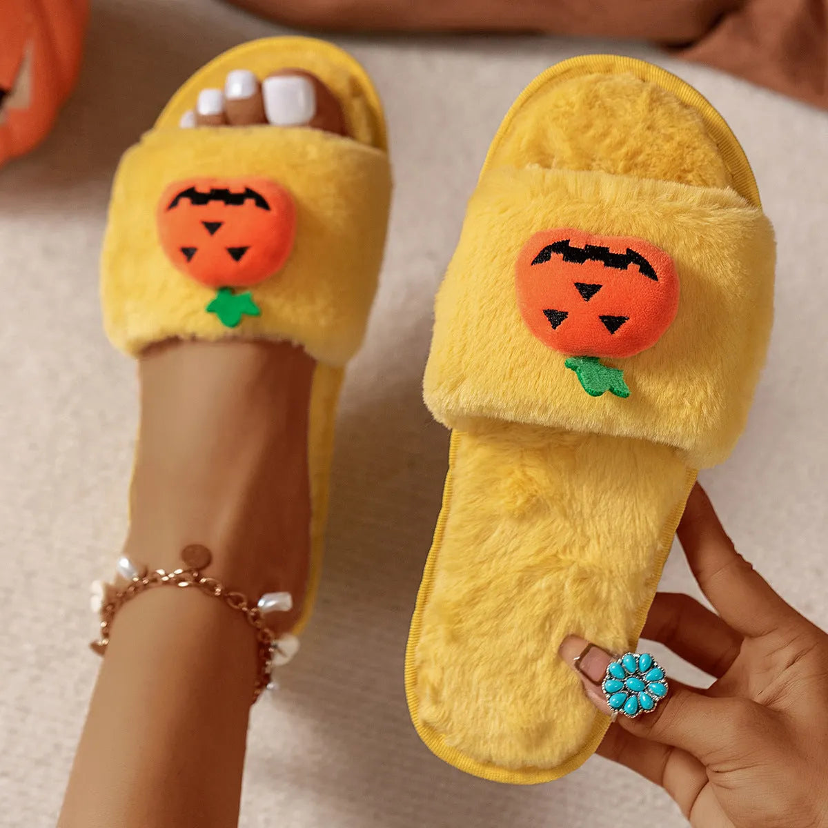 Yellow Halloween pumpkin plush open-toe slippers with synthetic fur and a light grey PVC anti-slip sole.