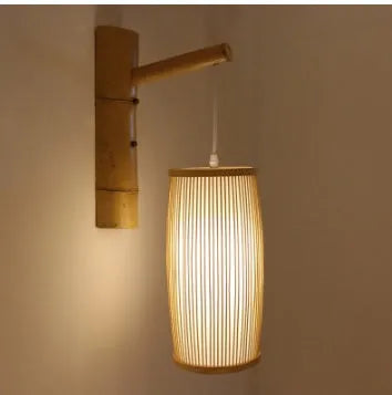 Hand-woven natural bamboo pendant lamp with open weave shade, hung from a black cord.