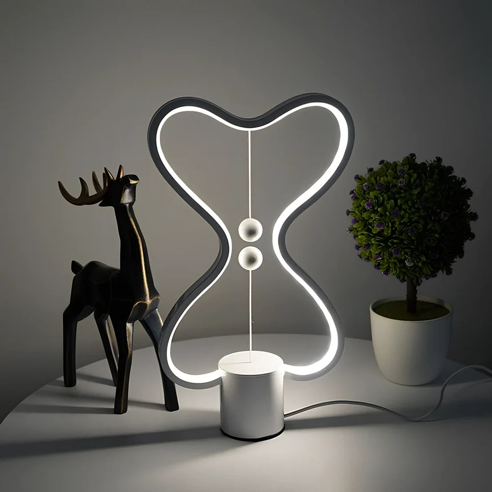 Balance lamp with suspended magnetic netballs and embedded LED lighting in frame