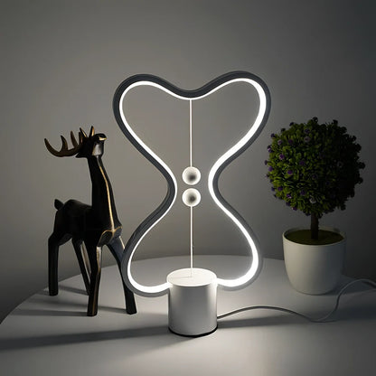 Balance lamp with suspended magnetic netballs and embedded LED lighting in frame