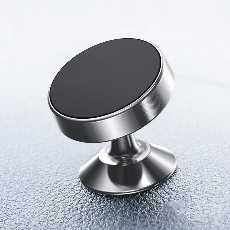 Black magnetic car phone holder with 360-degree ball joint mounted on a car air vent, holding a smartphone.