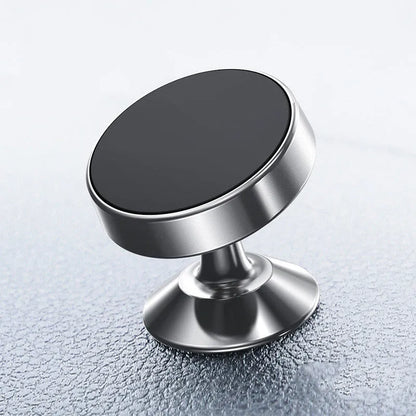 Black magnetic car phone holder with 360-degree ball joint mounted on a car air vent, holding a smartphone.