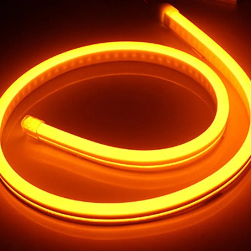 Close-up of flexible blue silicone LED neon strip showing dense LED beads, coiled on a 100-metre reel.