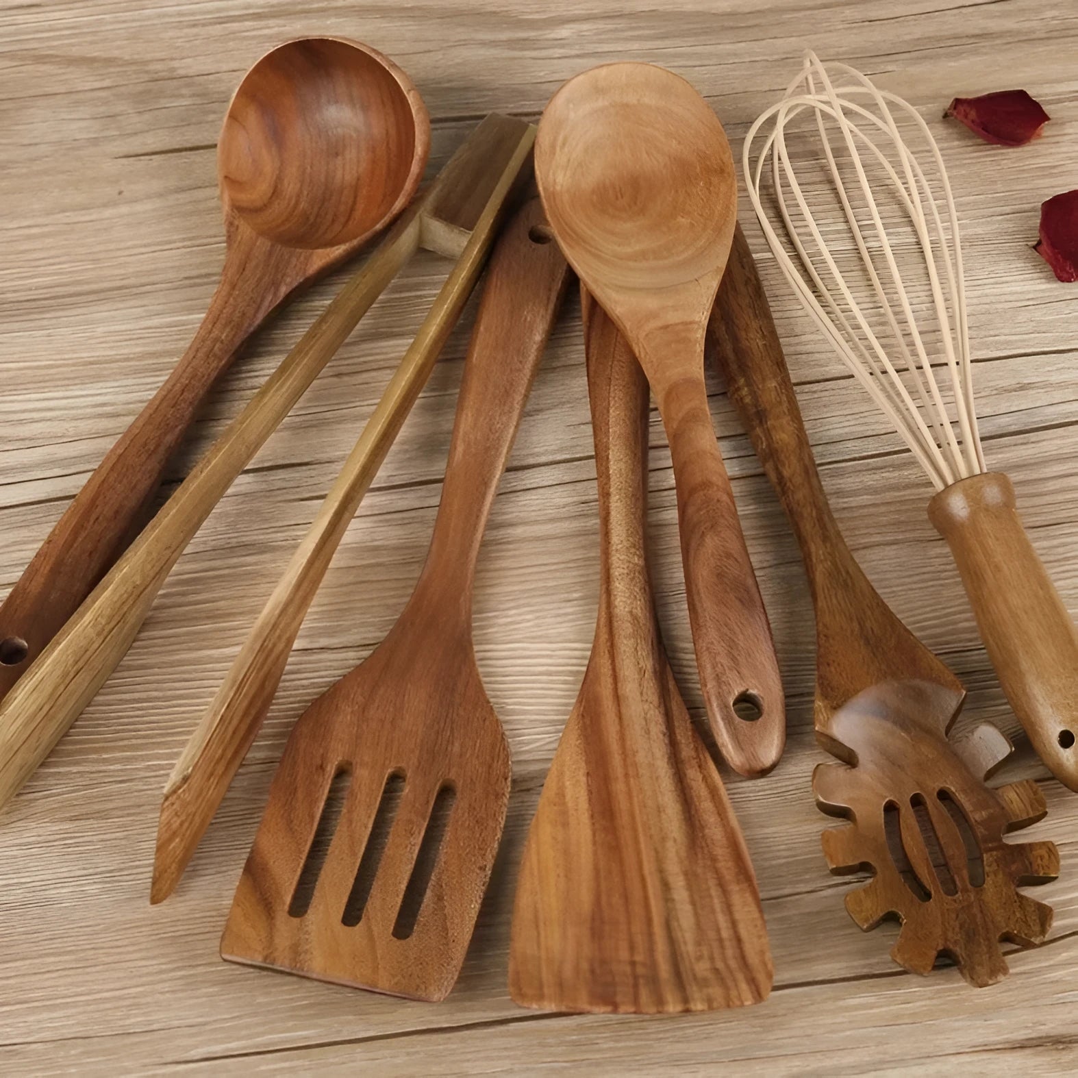 Set of seven light brown wooden cooking utensils including spoons, spatula, and turner on a kitchen counter.